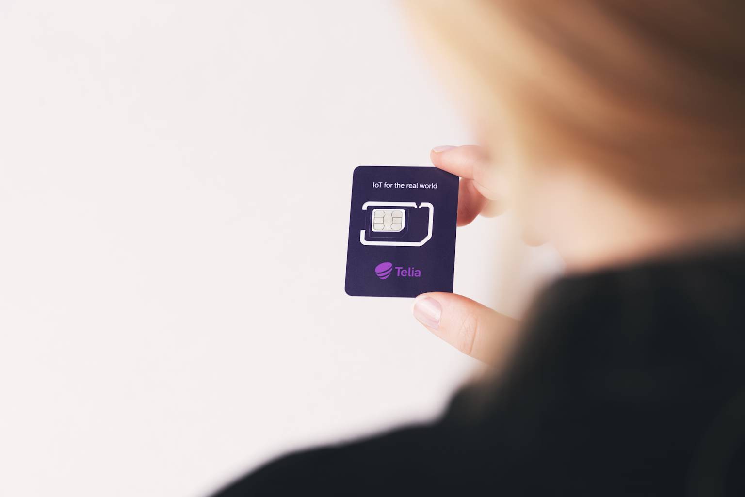 Person som håller i ett IoT-simkort