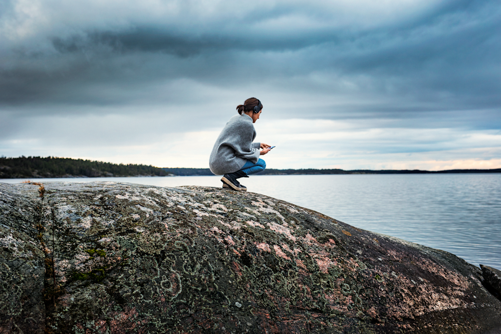 Person på klippor under blå himmel.