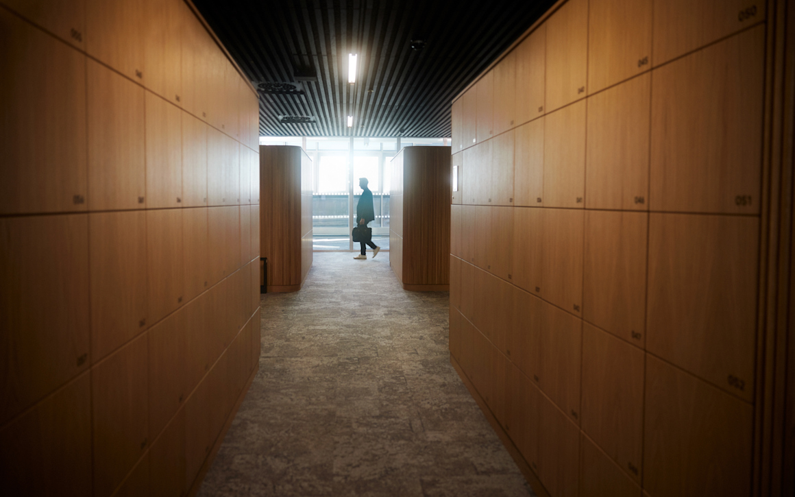 Man med portfölj som skymtar i slutet av korridor.