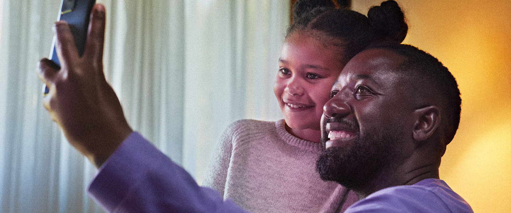 Pappa och dotter tar en selfie med mobilen.