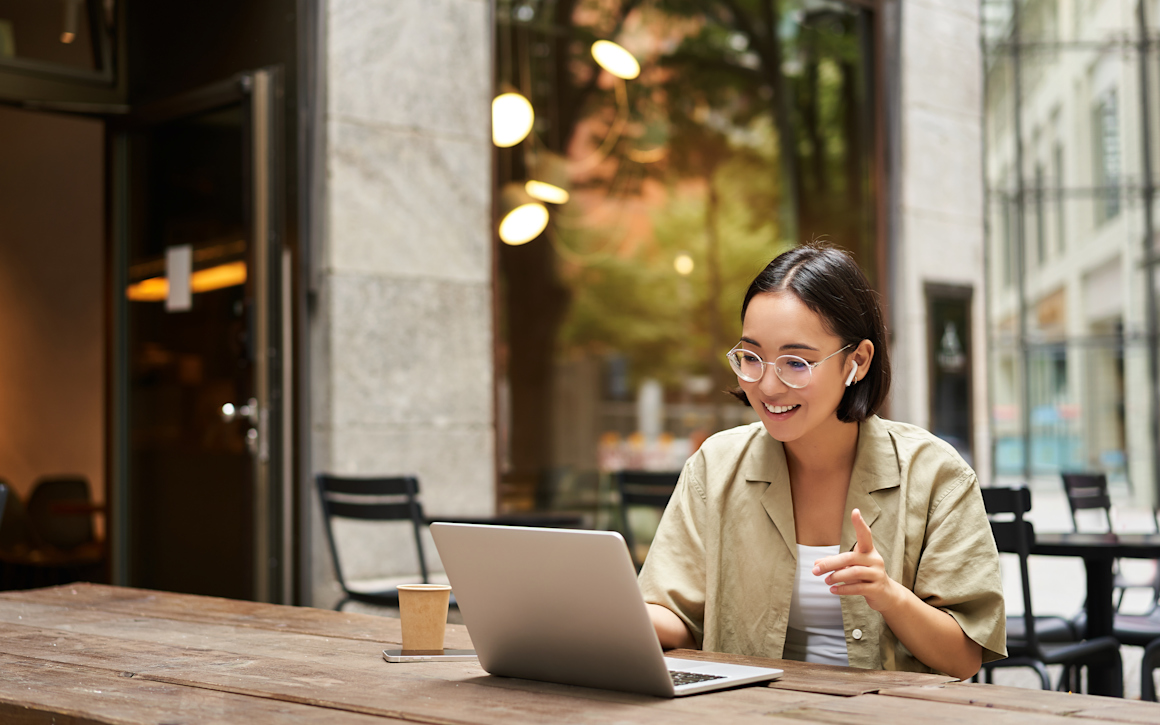 Kvinna arbetar utomhus med mobilt bredband.