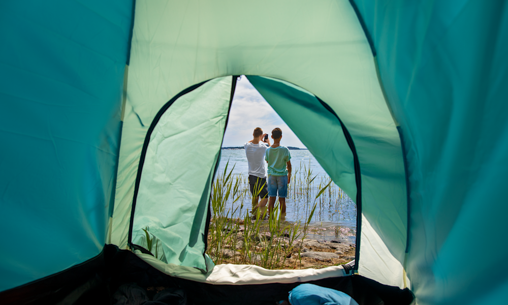 Tonårig pojke ligger på sidan och kollar mobilen