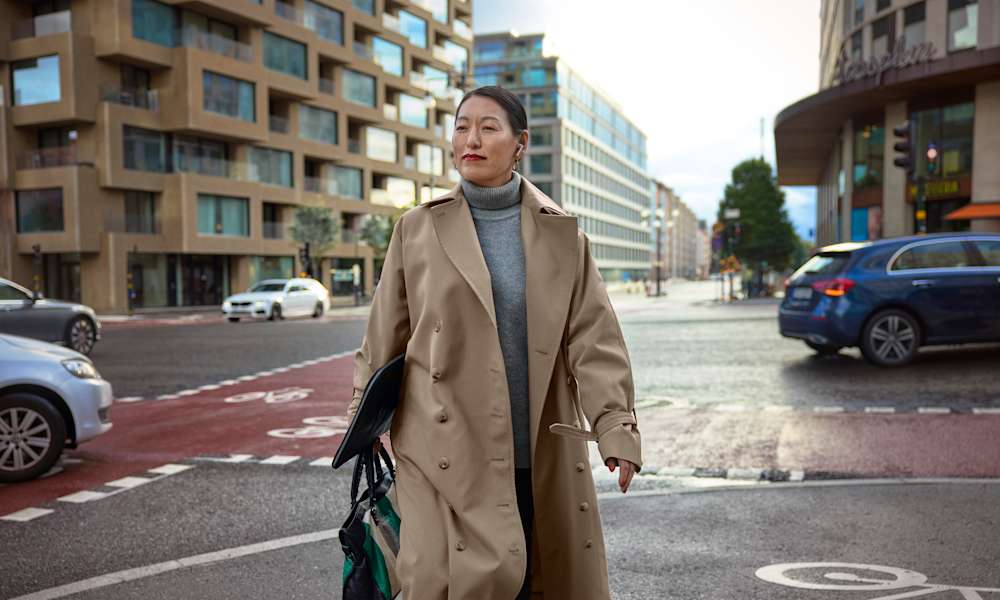 Kvinna med laptop går över gatan