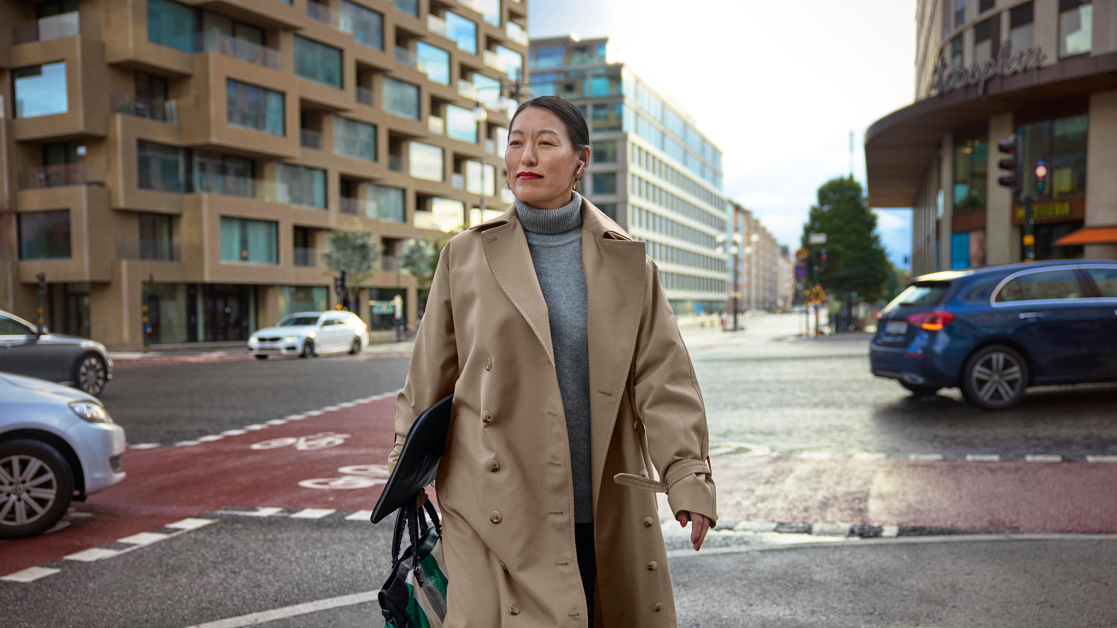 Kvinna med laptop går över gatan