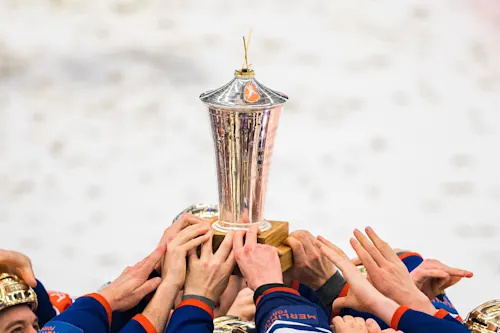 Bild på SHL-pokalen och spelare som höjder den i luften. Många lag har varit svenska mästare i Svenska Hockeyligan genom tiderna.