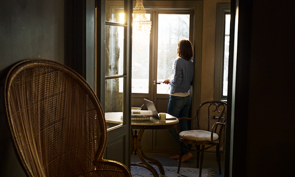 Kvinna med laptopdator nära ett fönster.