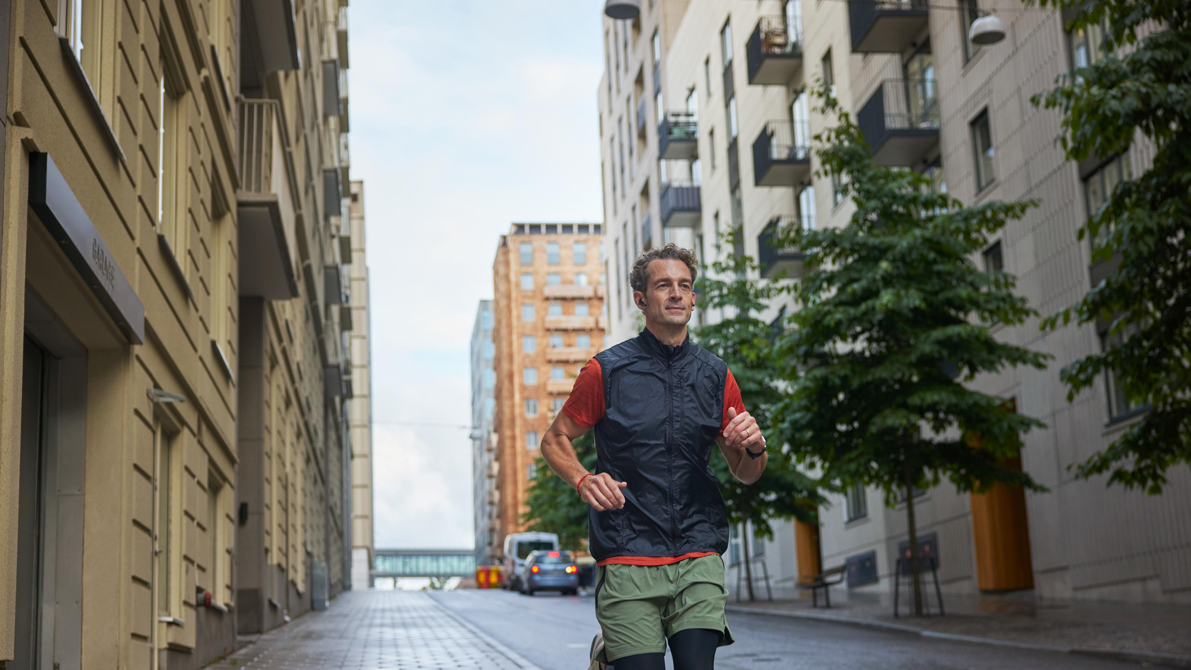 Man som springer på gata mellan hus