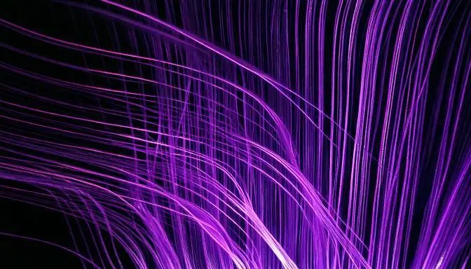 Mörk bild med lila streck som ska symbolisera fibertrådar