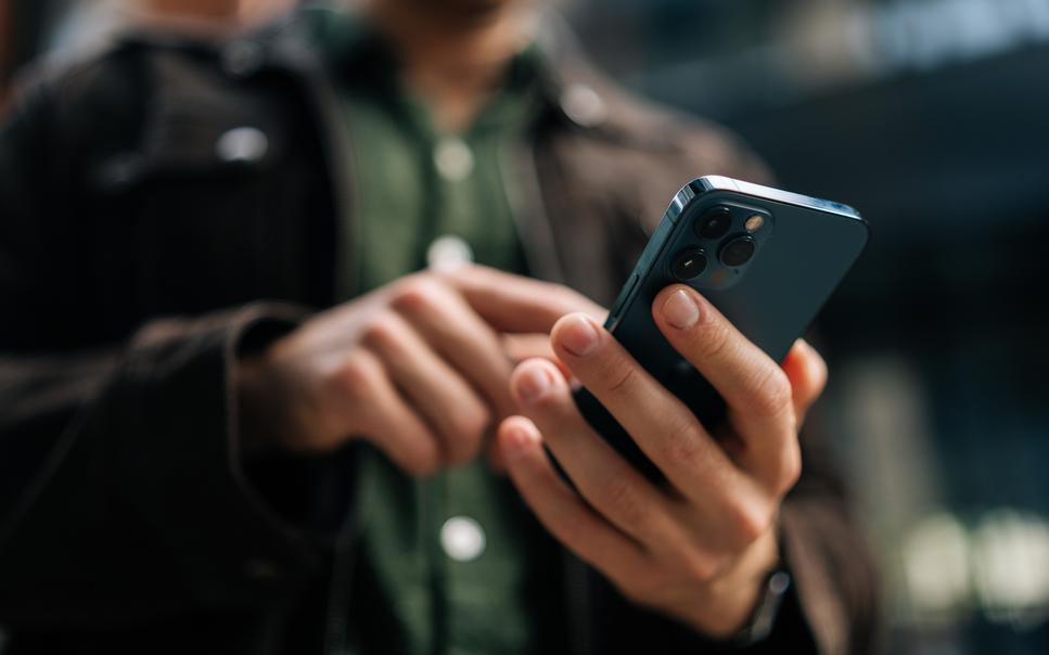 Close-up of a man's hands using a mobile phone.