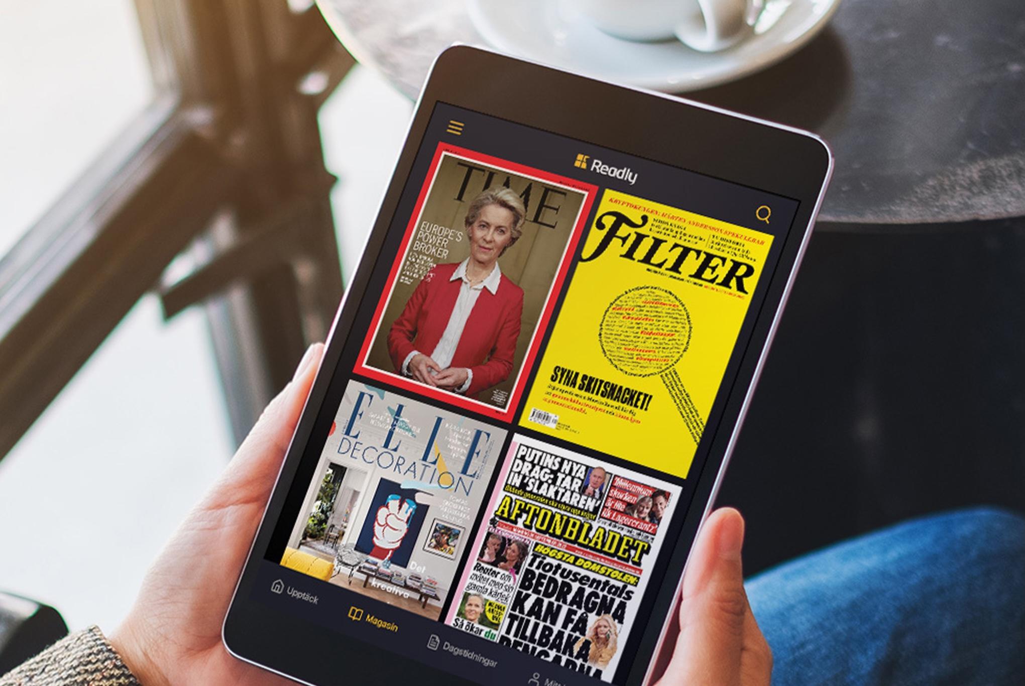 En surfplatta i någons knä som visar olika magasin i Readlys app
