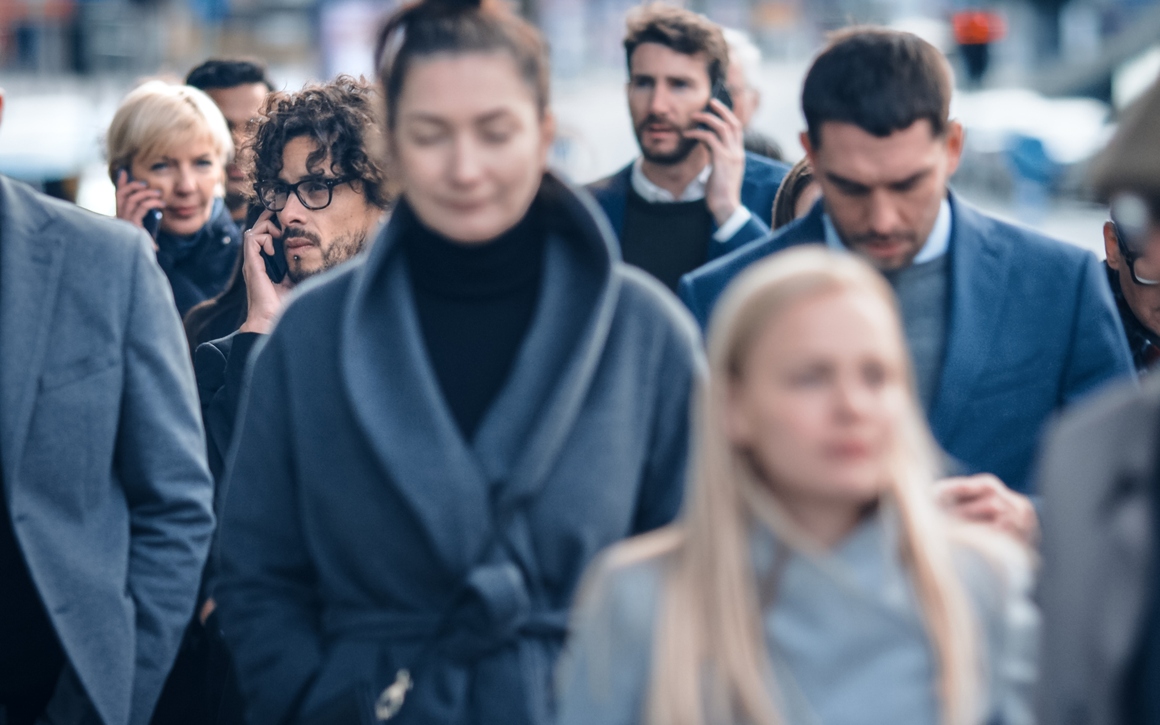 Arbetande människor som pratar i telefon i stad.