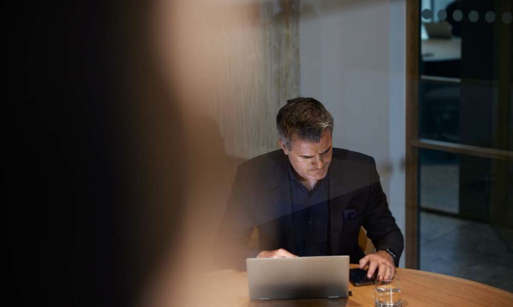 Man på kontor med laptop och mobil