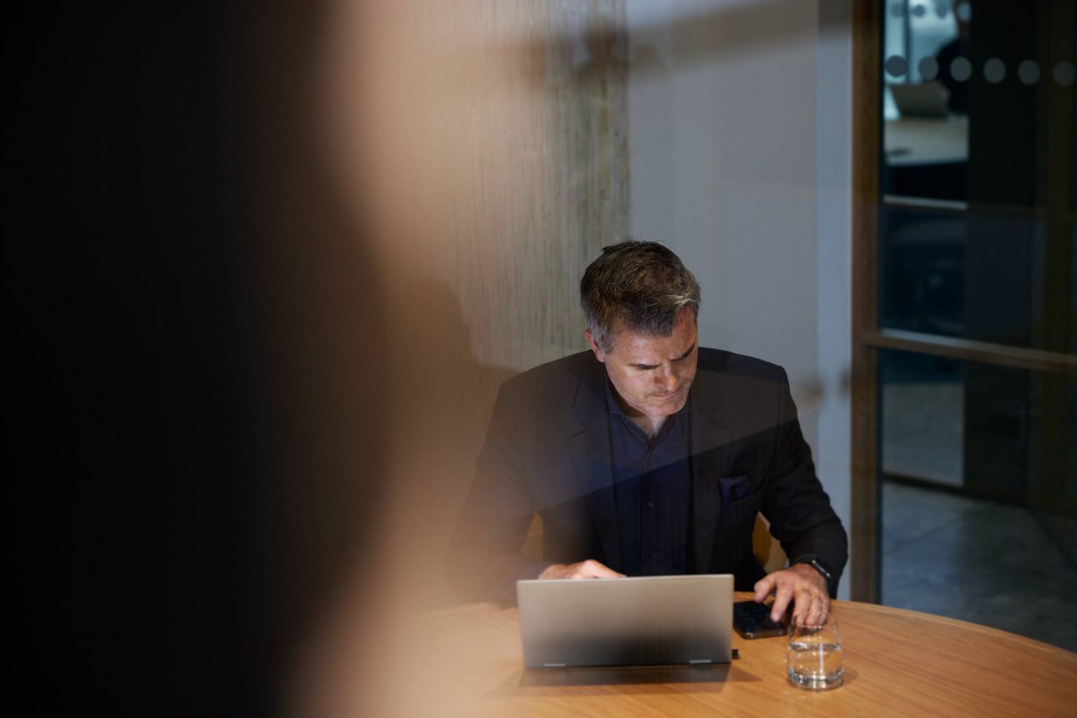 Man på kontor med laptop och mobil