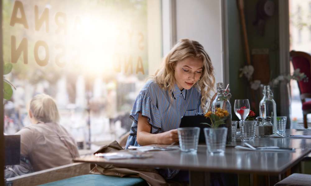 Kvinna arbetar vid restaurangdisk 