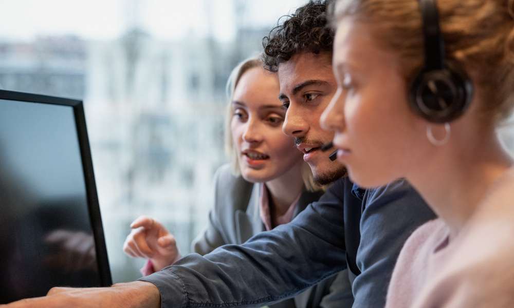 Three people in front of computer