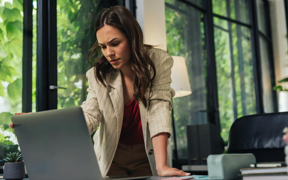 Woman with concerned expression looking at computer