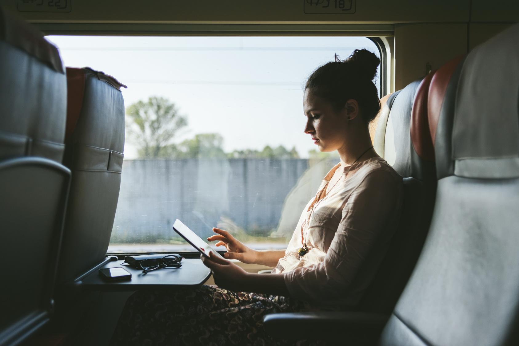 Kvinna på buss som arbetar på sin dator.