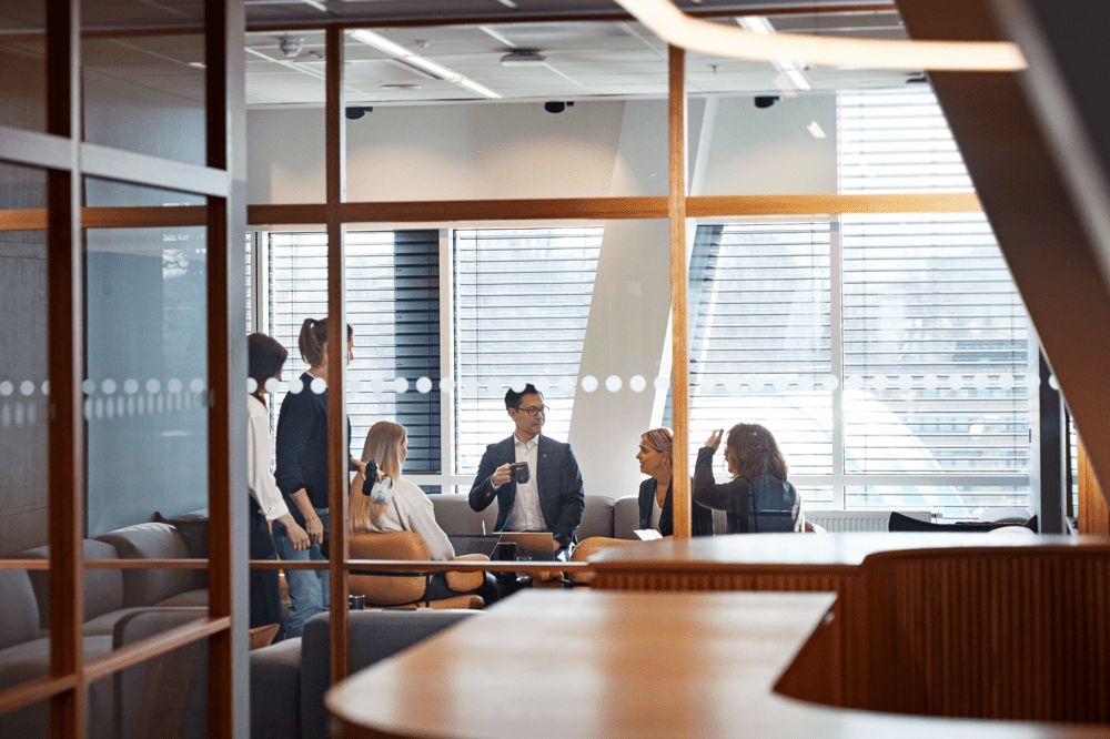 Kollegor pratar i kontorsmiljö.