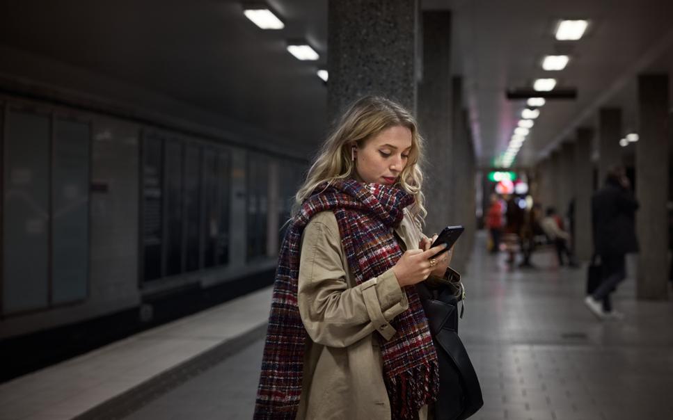 En kvinna som tittar ner i sin mobiltelefon.