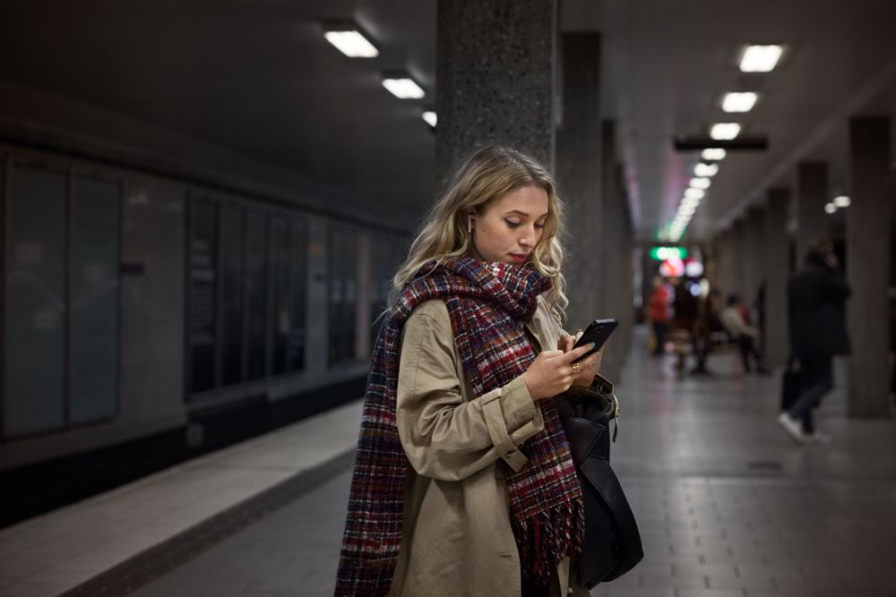 En kvinna som tittar ner i sin mobiltelefon.