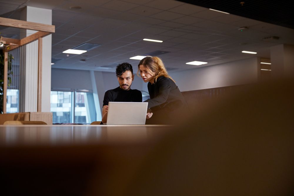 Kvinna arbetar med Smart Säkerhet på laptop på kontor.