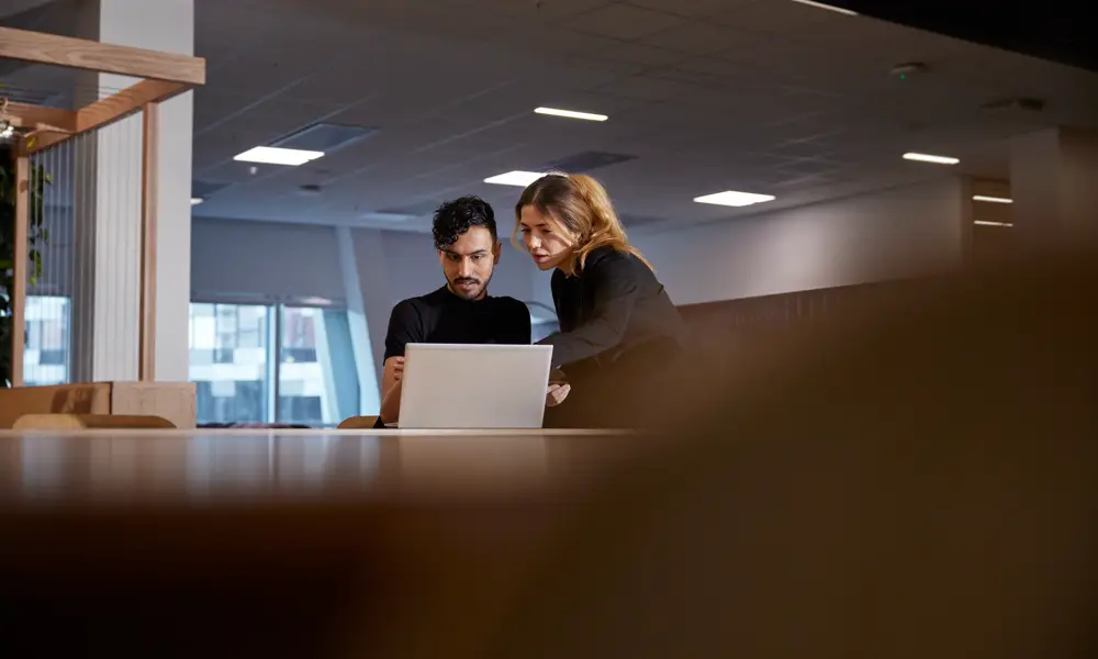 Kvinna och man på kontor med laptop
