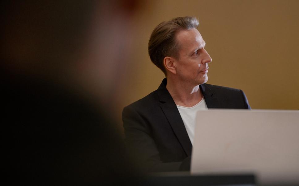 Man bakom laptop på kontor tittar framåt.