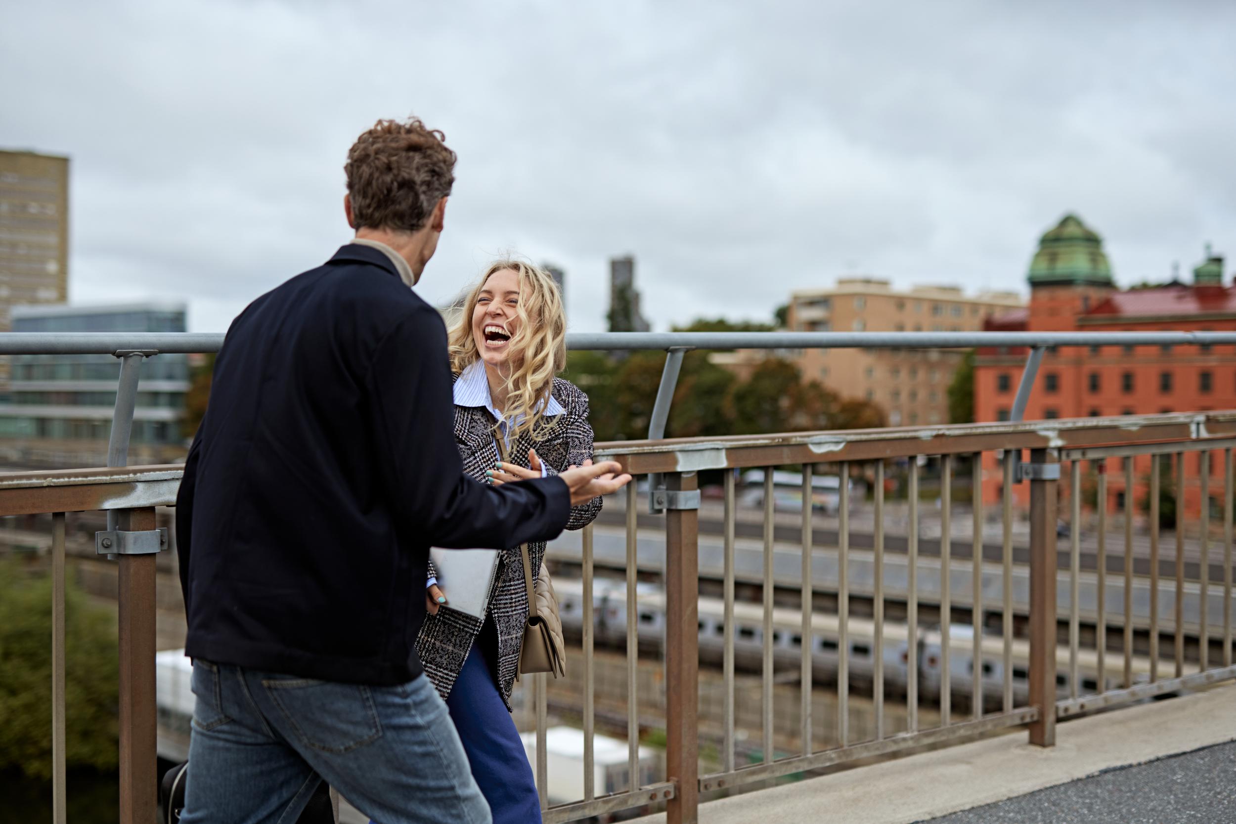 Kvinna och man pratar på takterrass i Stockholm