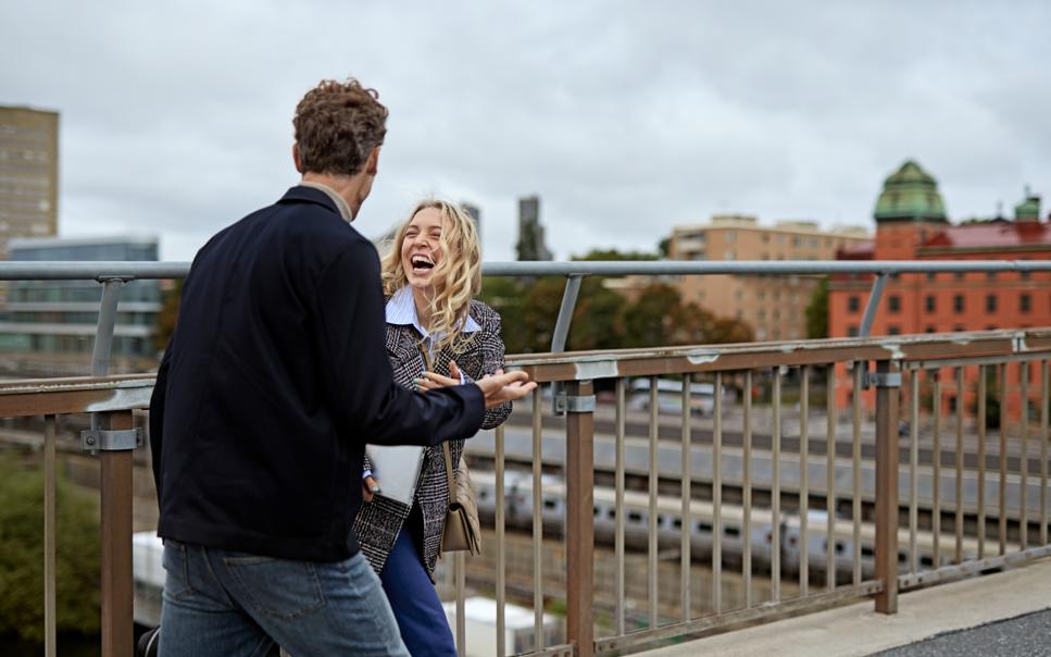 Kvinna och man pratar på takterrass i Stockholm.