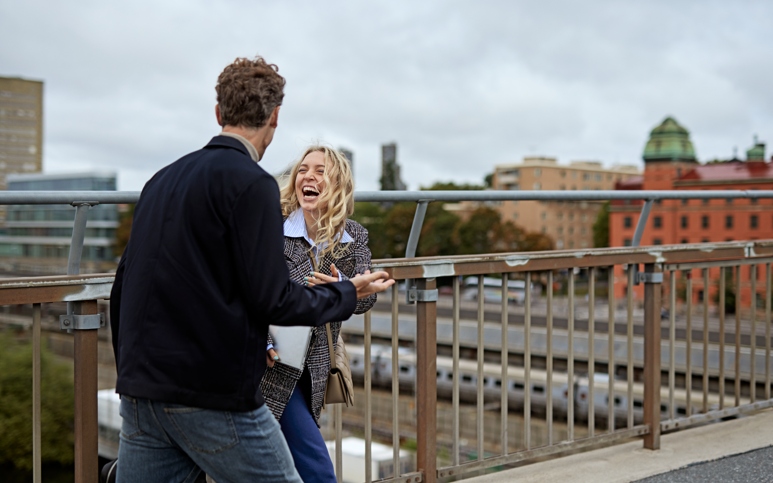 Kvinna och man pratar på takterrass i Stockholm