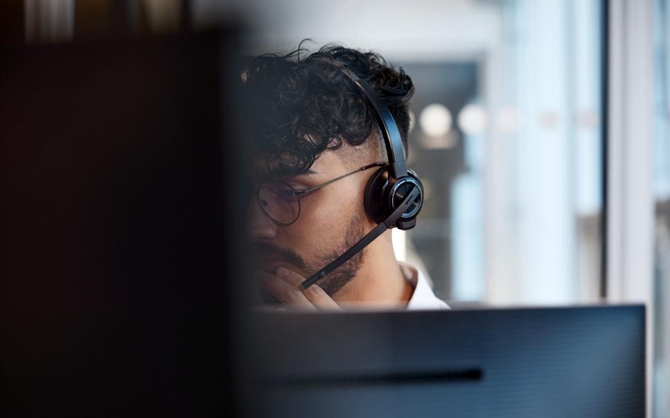 Man med headset framför dator