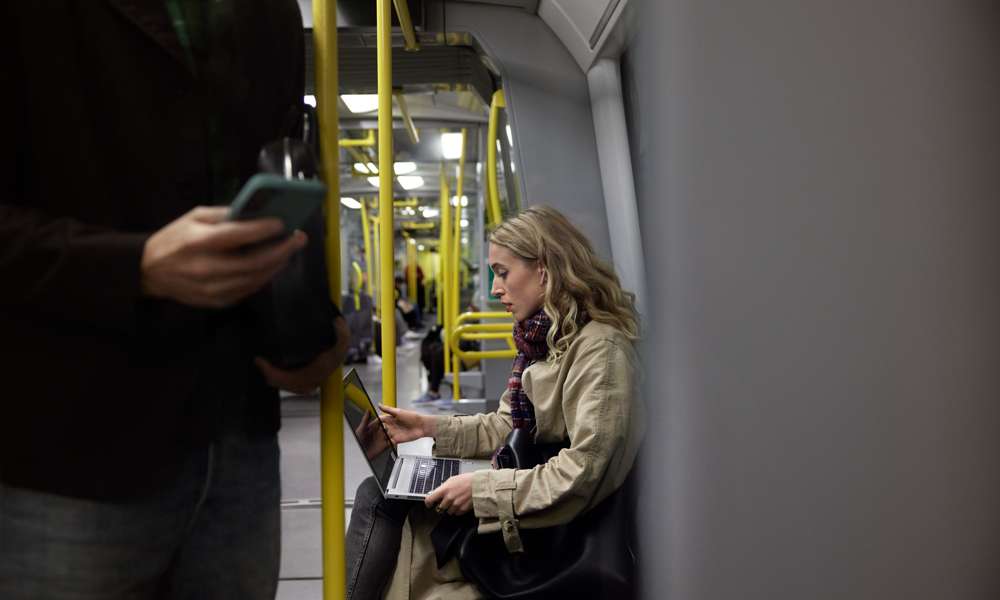 Kvinna arbetar med mobilt bredband på tunnelbanan.
