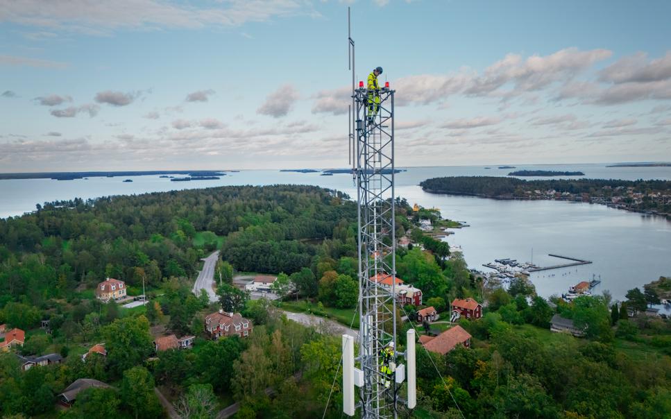 Arbetare från Telia arbetar uppe i mast.