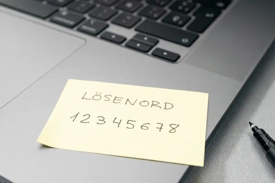 En post-it-lapp på en dator med ett svagt lösenord uppskrivet.
