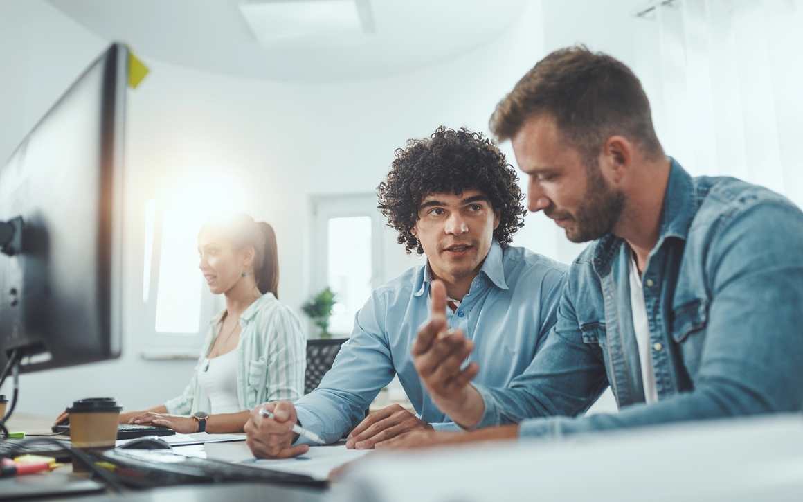 Team som jobbar med IT-support på ljust kontor.