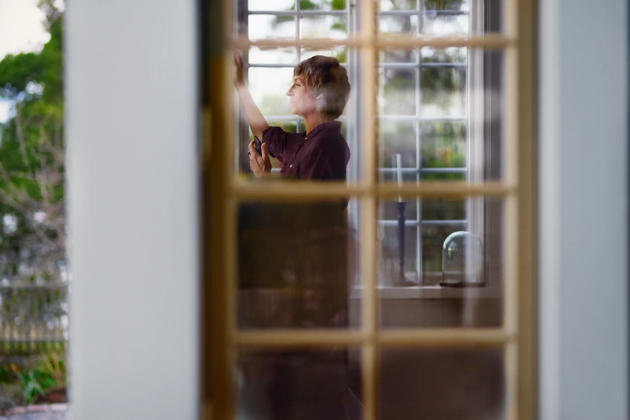 Äldre kvinna framför fönster