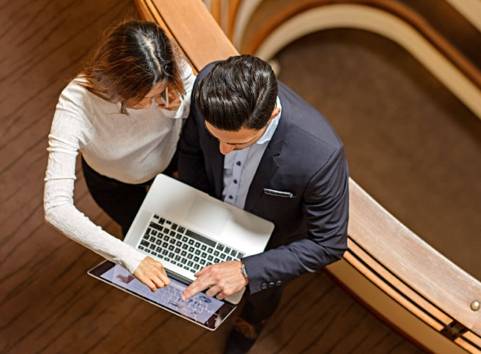 Man och kvinna pekar på dator