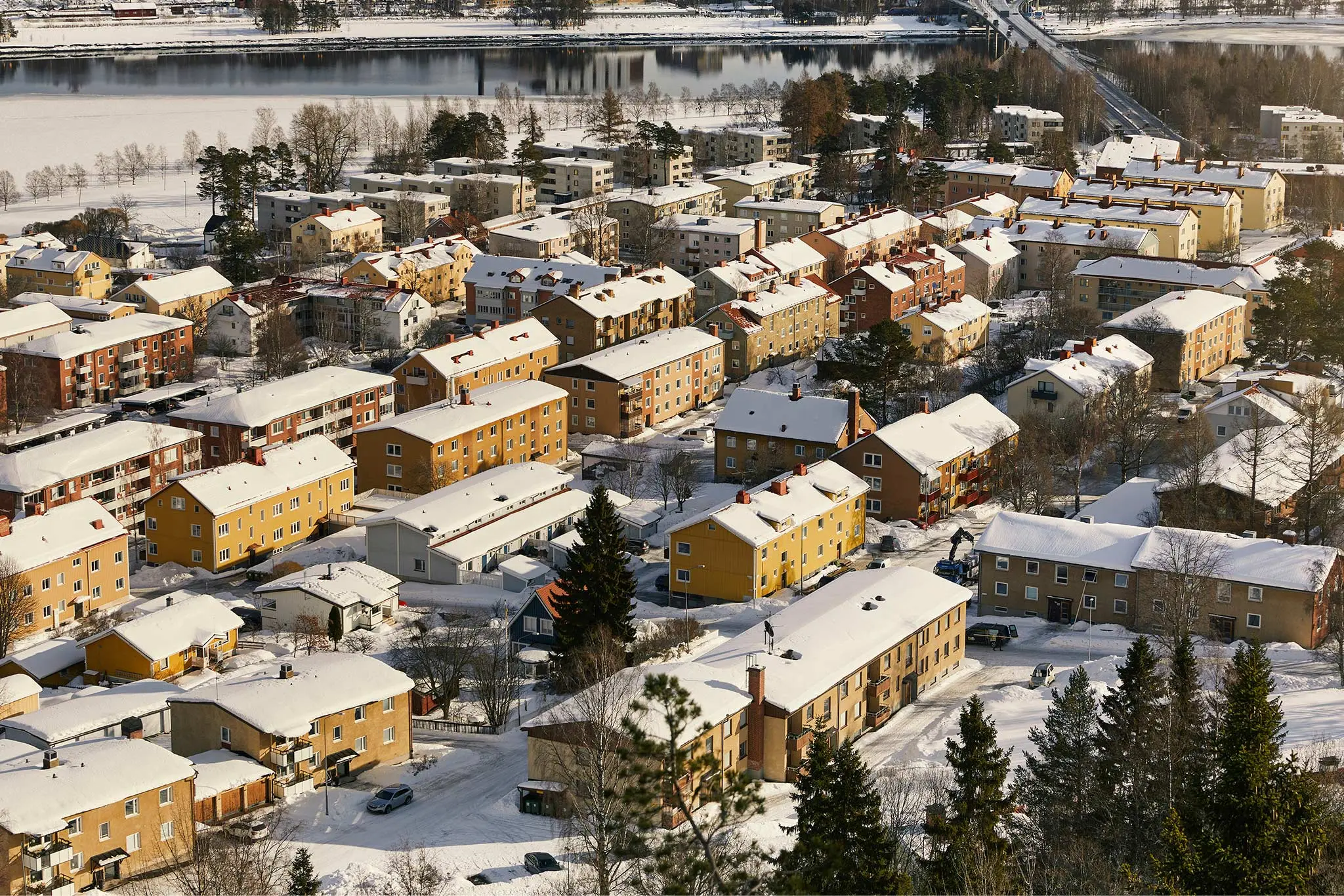 Ett lägenhetskomplex i ett vinterlandskap, där marken och hustaken är täckta av snö som illustrerar ett exempel på var det passar alldeles utmärkt med bredband via fiber.
