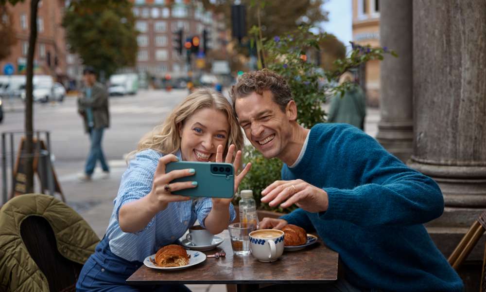 kvinna och man tar selfie på kafe 