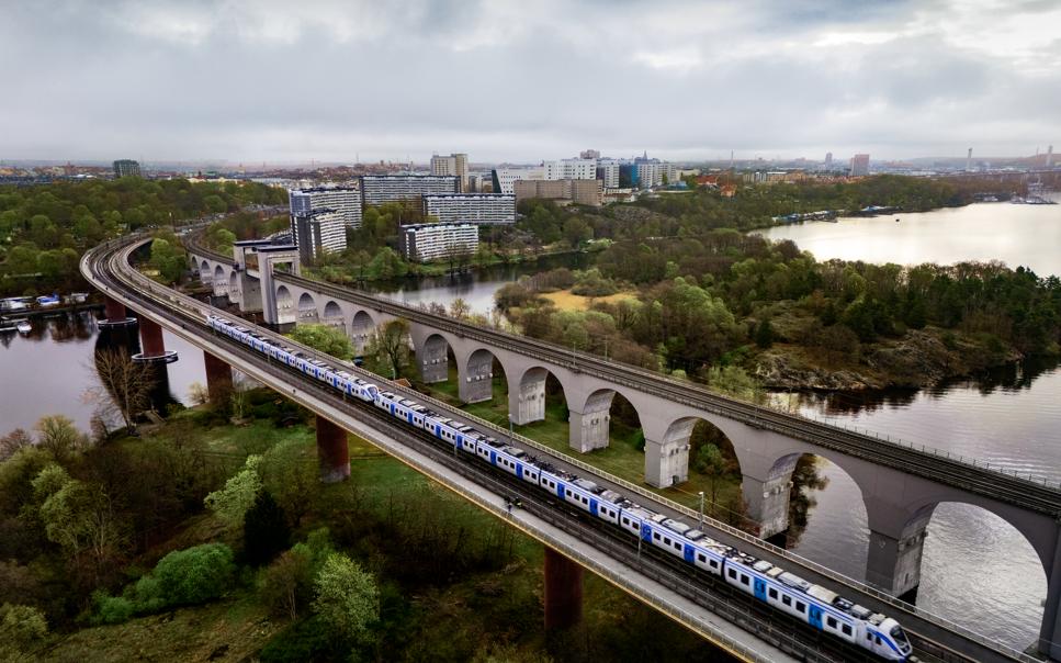 Tunnelbanetåg som kör på en bro över vatten.