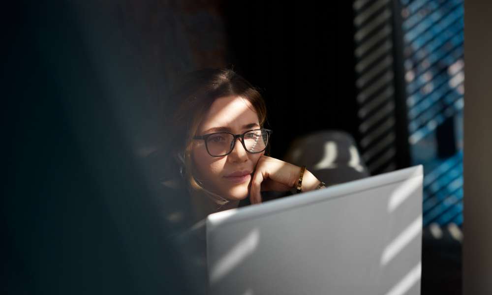 Kvinna sitter med sin bärbara dator.