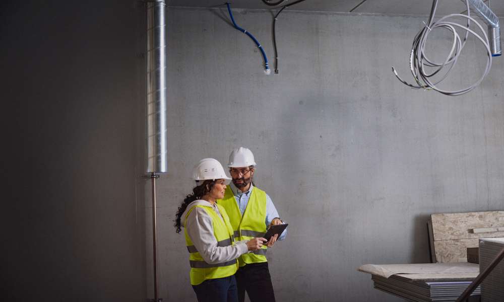 Man och kvinna med platta på byggarbetsplats
