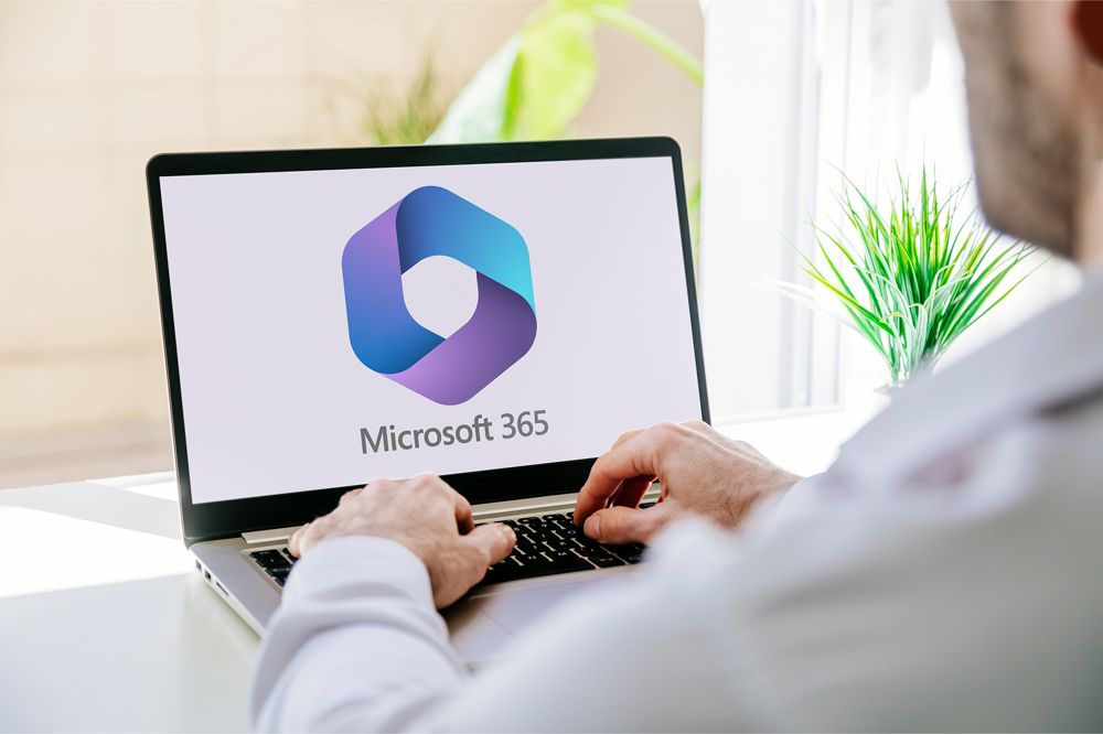 Microsoft 365-logga på laptop, man klickar på tangenterna.