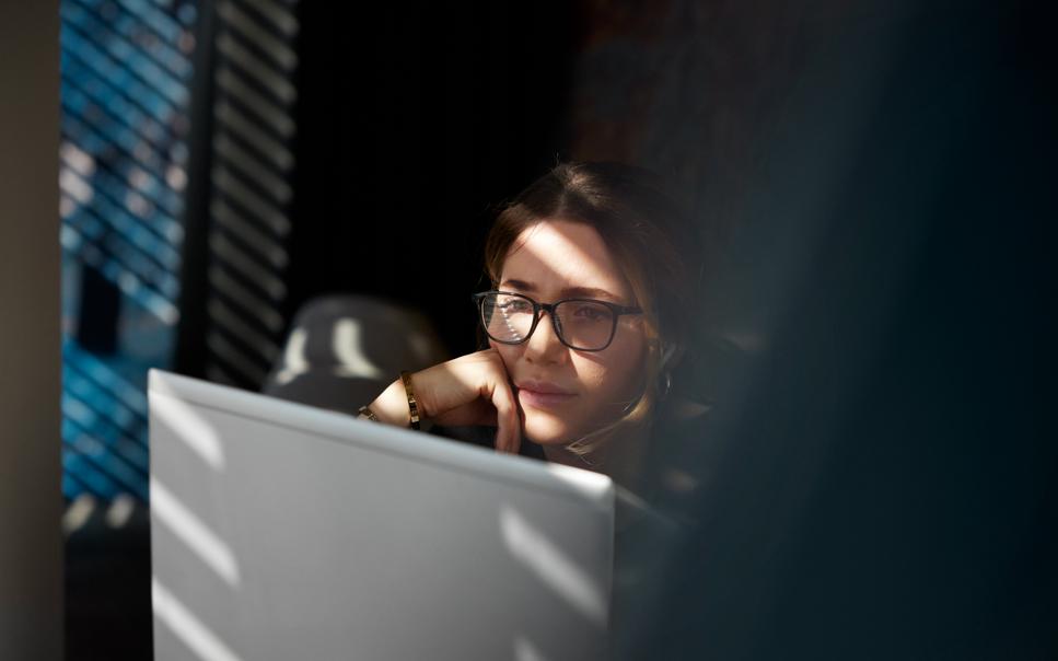 Kvinna orolig för cybersäkerhet framför laptop.